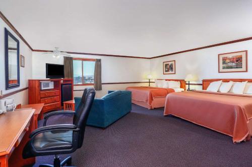 a hotel room with two beds and a blue couch at Longhorn Hotel in Helena