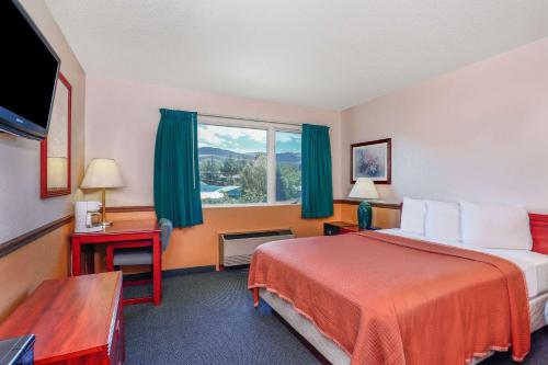 a hotel room with a bed and a window at Howard Johnson by Wyndham Helena in Helena