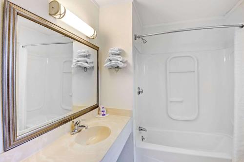 a bathroom with a sink and a mirror at Budget Inn in South Portland