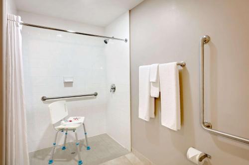 uma casa de banho com um chuveiro e um banco. em Super 8 by Wyndham Kapuskasing em Kapuskasing