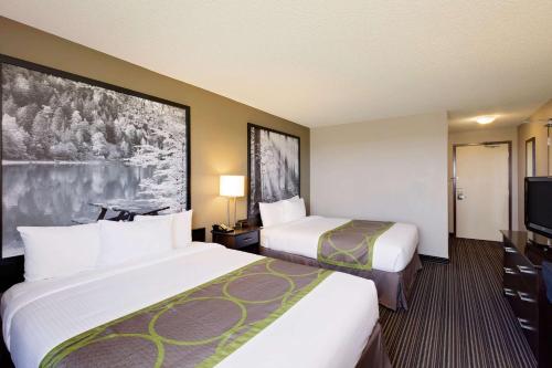 um quarto de hotel com duas camas e uma televisão de ecrã plano em Super 8 by Wyndham Kapuskasing em Kapuskasing