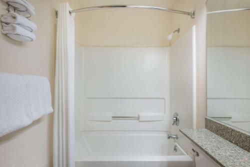 a white bathroom with a tub and a shower at Knights Inn Allentown in Allentown