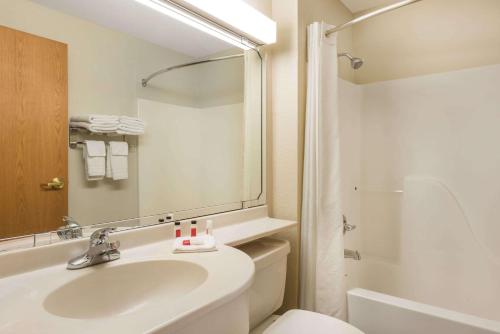 un bagno con lavandino, WC e specchio di Microtel Inn & Suites by Wyndham Sainte Genevieve a Sainte Genevieve