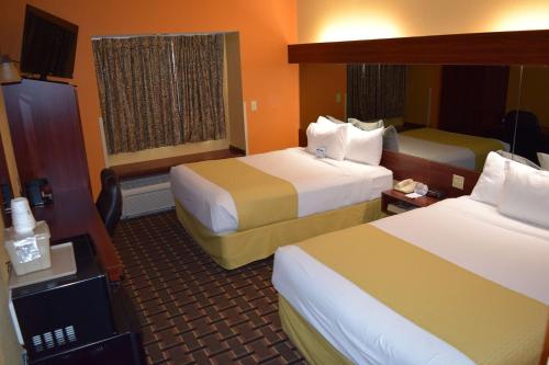 a hotel room with two beds and a television at Microtel Inn & Suites by Wyndham Rock Hill/Charlotte Area in Rock Hill