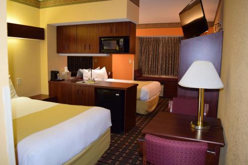 a hotel room with two beds and a desk with a lamp at Microtel Inn & Suites by Wyndham Rock Hill/Charlotte Area in Rock Hill