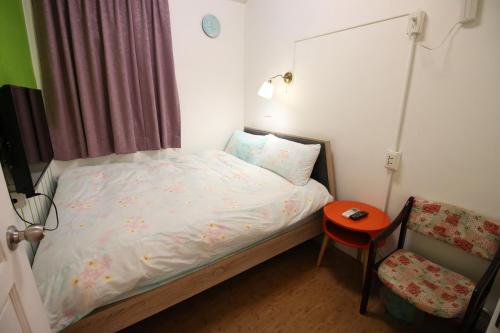 a small bedroom with a bed and a chair at Corner Inn九份住宿I 小角落民宿I 機車租借I日夜間導覽 in Jiufen