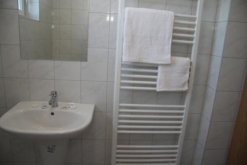 a bathroom with a sink and a shower with towels at Bagoly Fogadó in Gyömrő