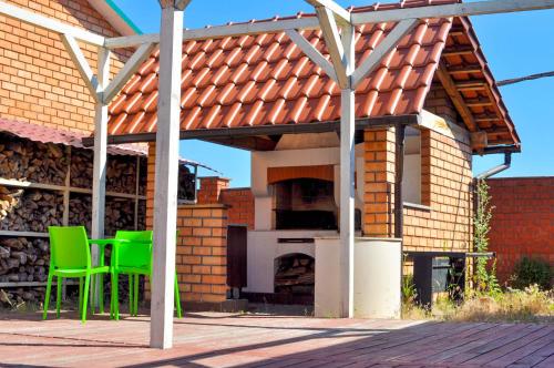a patio with green chairs and an outdoor oven at Klever-ok in Nerubayskoye