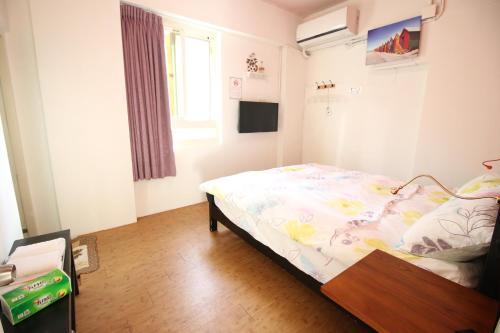 a small bedroom with a bed and a window at Corner Inn九份住宿I 小角落民宿I 機車租借I日夜間導覽 in Jiufen