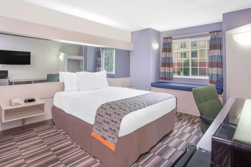 a hotel room with a large bed and a television at Microtel Inn and Suites by Wyndham Appleton in Appleton