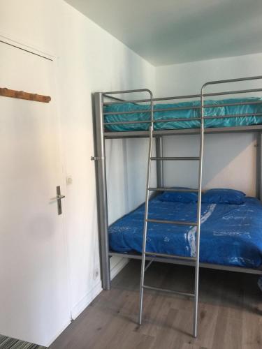 Ce lit superposé se trouve dans un dortoir doté d'une croix sur le mur. dans l'établissement Studio Bord de Plage des Bas Sablons Saint Malo, à Saint-Malo
