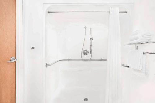 a shower in a bathroom with a glass door at Microtel Inn & Suites Beckley East in Beckley