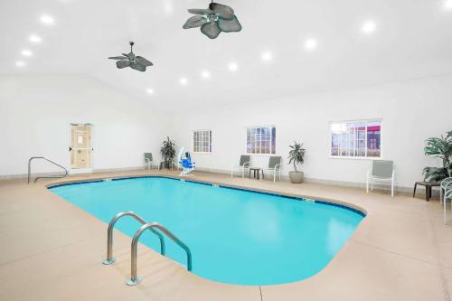 a large swimming pool in a room with tables and chairs at Microtel Inn & Suites Beckley East in Beckley