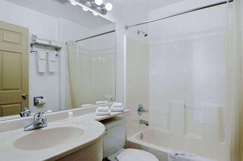 a bathroom with a sink and a toilet and a tub at Eagle River Microtel in Eagle River
