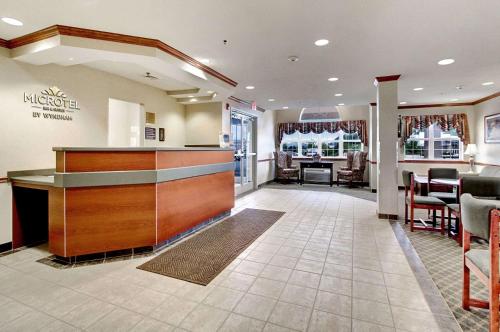 a lobby of a hotel with a bar in it at Microtel Inn & Suites by Wyndham Bridgeport in Bridgeport