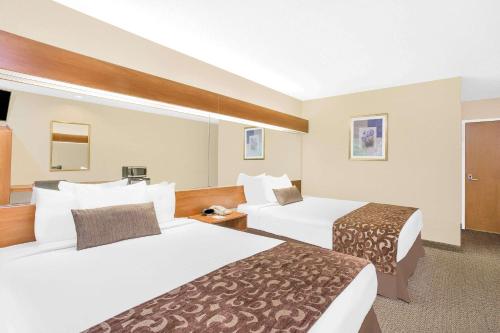 a hotel room with two beds in a room at Microtel Inn & Suites Beckley East in Beckley