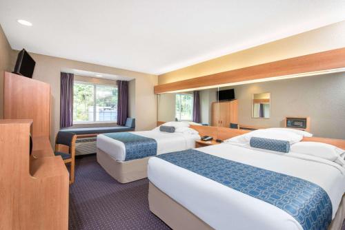 Cette chambre comprend deux lits et une télévision. dans l'établissement Microtel Inn & Suites by Wyndham Hazelton/Bruceton Mills, à Hazelton