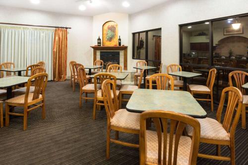 a dining room with tables and chairs and a fireplace at Hawthorn Suites by Wyndham Napa Valley in Napa