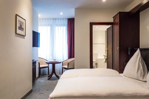 a hotel room with a bed and a table at Hotel Imperial in Cologne