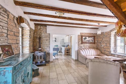 Una sala de estar con un sofá y una pared de piedra. en Villa Postaja, en Kanfanar