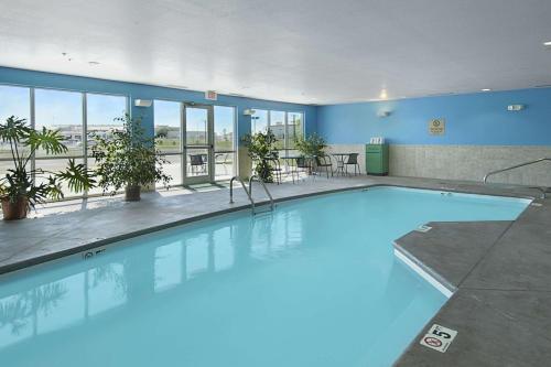 a large pool with blue water in a building at Super 8 by Wyndham Topeka at Forbes Landing in Topeka