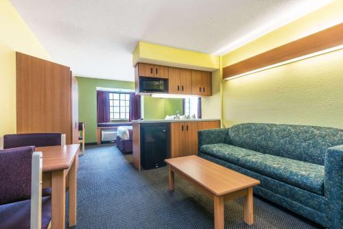 a living room with a couch and a table at Microtel Inn & Suites by Wyndham Auburn in Auburn