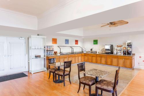 una cucina con tavolo, sedie e frigorifero di Hawthorn Suites a Victorville