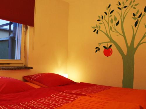 ein Schlafzimmer mit einem Baum mit einem Apfel an der Wand in der Unterkunft Seaside Bungalow with Terrace, Garden, Barbecue, Parking in Insel Poel