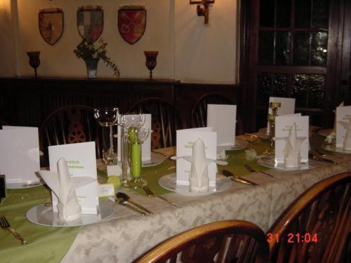 a table with a green and white table cloth and chairs at Hotel Schmidt in Selb