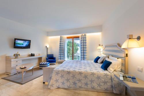 a bedroom with a king sized bed and a desk at Grande Baia Resort & Spa in San Teodoro