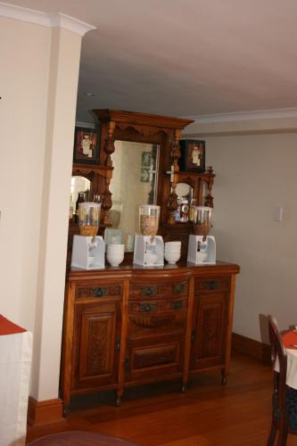a wooden dresser with bowls on top of it at Knysna Manor House in Knysna