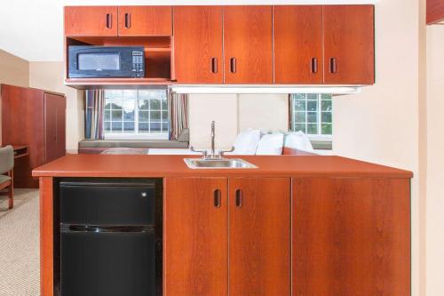 a kitchen with a sink and a microwave at Microtel Inn by Wyndham Rogers in Rogers
