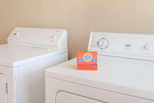 two white washing machines and a box on a counter at Lincoln Inn Fredericton in Fredericton