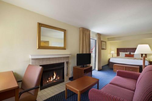 Habitación de hotel con chimenea y cama en Affordable Suites of America Grand Rapids, en Grand Rapids