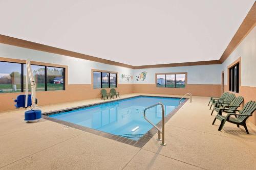 a large swimming pool with chairs around it at Howard Johnson by Wyndham Waterloo/Cedar Falls in Waterloo