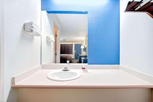 a bathroom with a sink and a mirror at Dallas Love Field Inn in Dallas