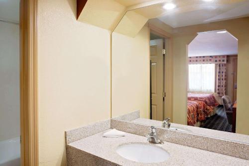 a bathroom with a sink and a large mirror at Knights Inn Port Charlotte in Port Charlotte