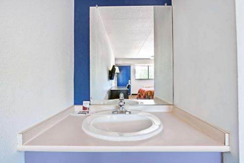 a bathroom with a sink and a mirror at Dallas Love Field Inn in Dallas