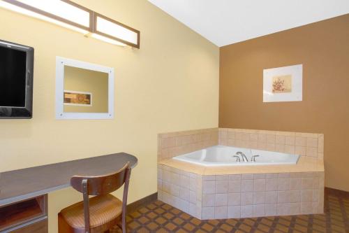 a large bathroom with a tub and a chair at Microtel Inn & Suites by Wyndham Harrisonburg in Harrisonburg
