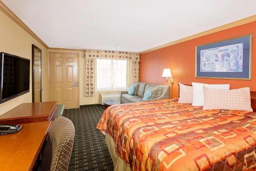 a hotel room with a bed and a desk at Knights Inn Port Charlotte in Port Charlotte