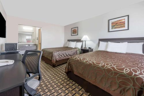 a hotel room with two beds and a desk at Knights Inn - Slaton in Slaton