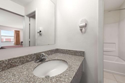 a bathroom with a sink and a mirror at Knights Inn - Slaton in Slaton