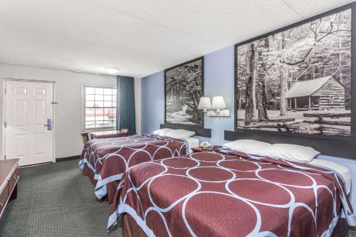 ein Hotelzimmer mit 2 Betten und einem Gemälde an der Wand in der Unterkunft Super 8 by Wyndham Kingston in Kingston