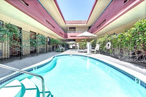 a swimming pool in a building with an umbrella at Vantage Point Inn - Woodland Hills in Woodland Hills