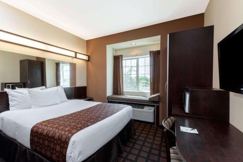 イーグル・パスにあるMicrotel Inn and Suites Eagle Passのベッドとテレビが備わるホテルルームです。