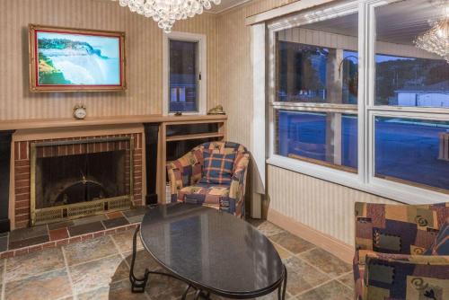 a living room with a glass table and a fireplace at Elite Inn in Moosup