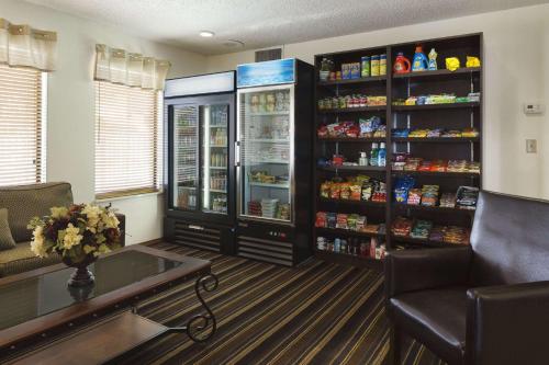 a room with a refrigerator and a table and chairs at Hawthorn Extended Stay by Wyndham Fort Wayne in Fort Wayne