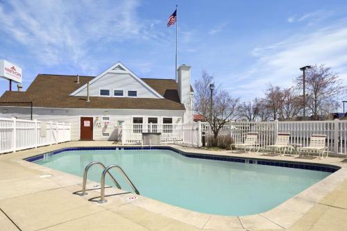 a swimming pool in front of a house with a flag at Hawthorn Extended Stay by Wyndham Fort Wayne in Fort Wayne