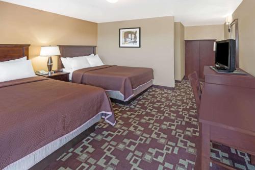 ein Hotelzimmer mit 2 Betten und einem Flachbild-TV in der Unterkunft Travelodge by Wyndham Newport in Newport