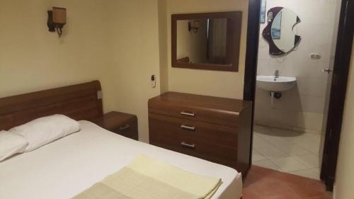 a bedroom with a bed and a sink and a mirror at Apartment in Porto Sokhna Pyramids for Families in Ain Sokhna